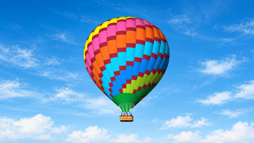 Pestrobarevný balón na modré obloze